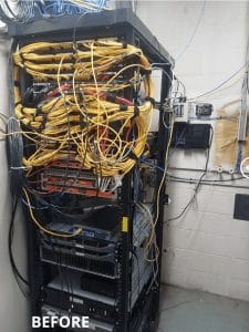 A cluttered network rack with tangled data cables in various directions before undergoing Rack Refresh IMAC Service